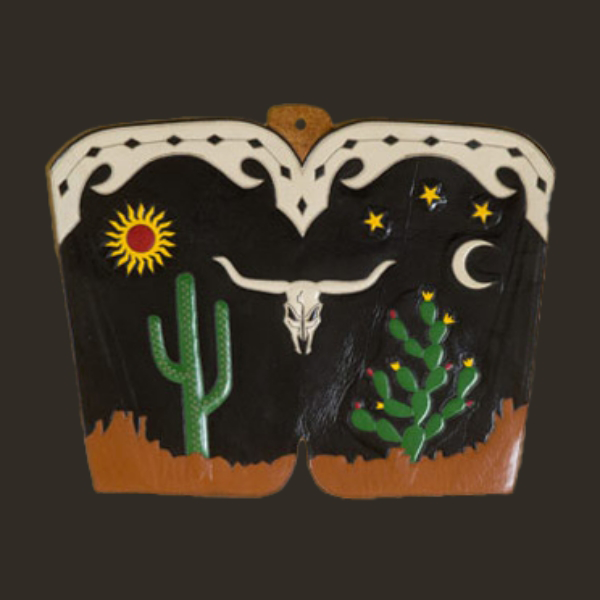A decorative boot top featuring a desert scene with a sun, stars, moon, cacti, and a bull skull.