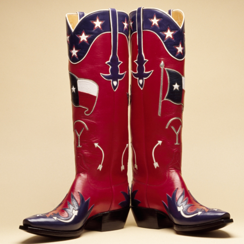 Red, white, and blue handmade cowboy boots with Texas-themed designs, including the state flag and lone star, set against a plain background.