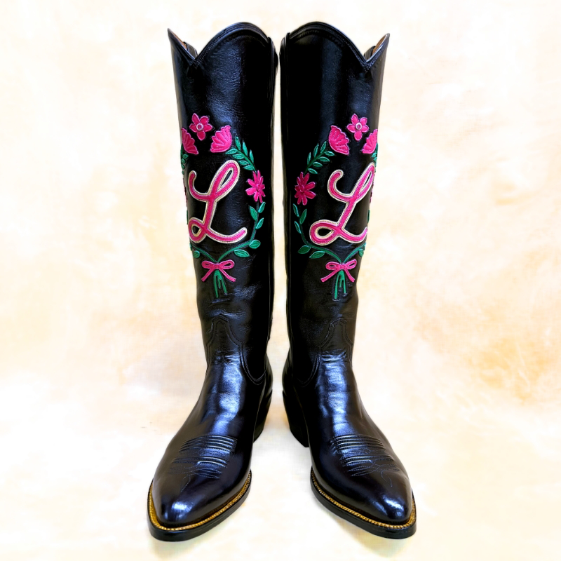 Custom black cowboy boots with pink floral embroidery and a personalized monogram for San Antonio Fiesta by Little’s Boot Company.