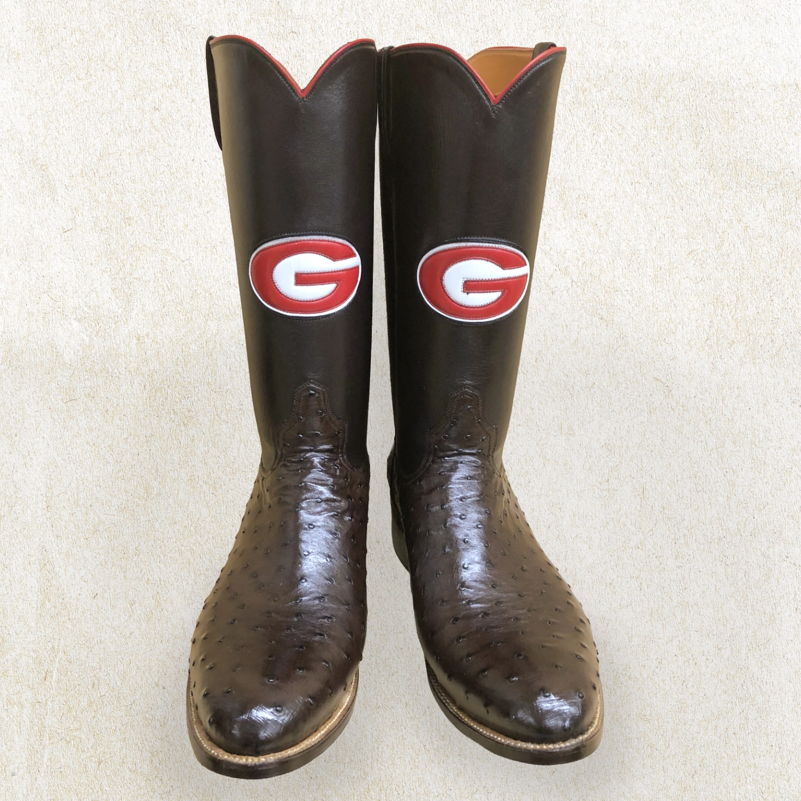 Handcrafted by Little’s Boot Company, these ostrich leather UGA boots showcase bold Georgia “G” logos on tall shafts.